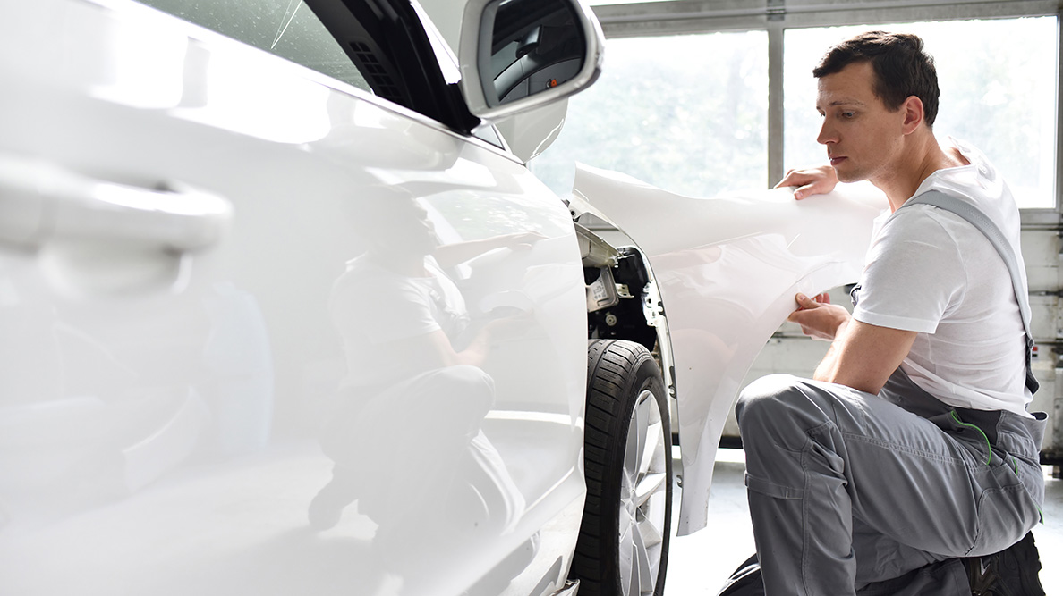 Collision repair technicians with vehicle