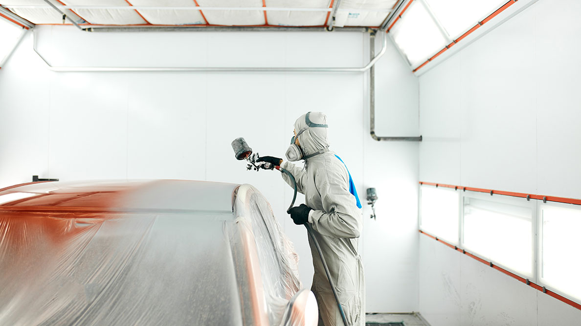 Painter in an auto body shop working in the paint booth